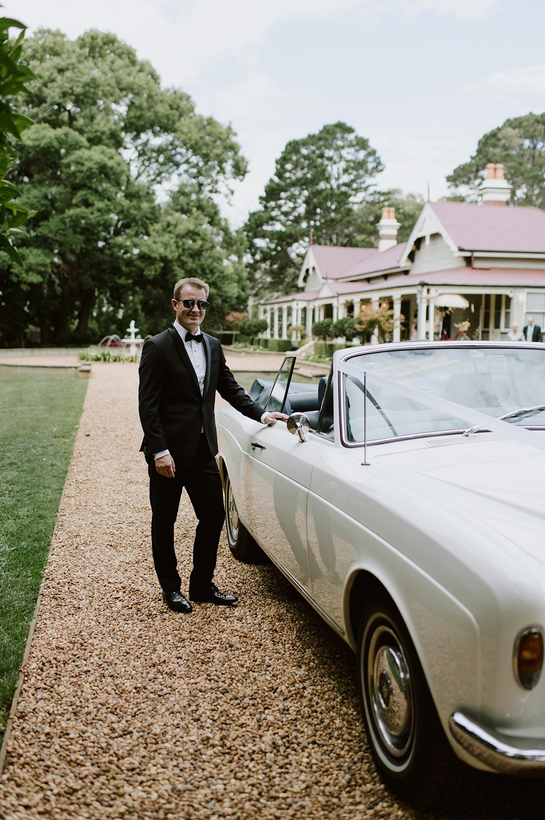 Groom standing next to car