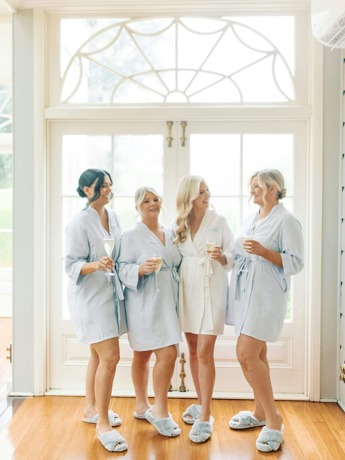 Bride and bridesmaids drinking champagne