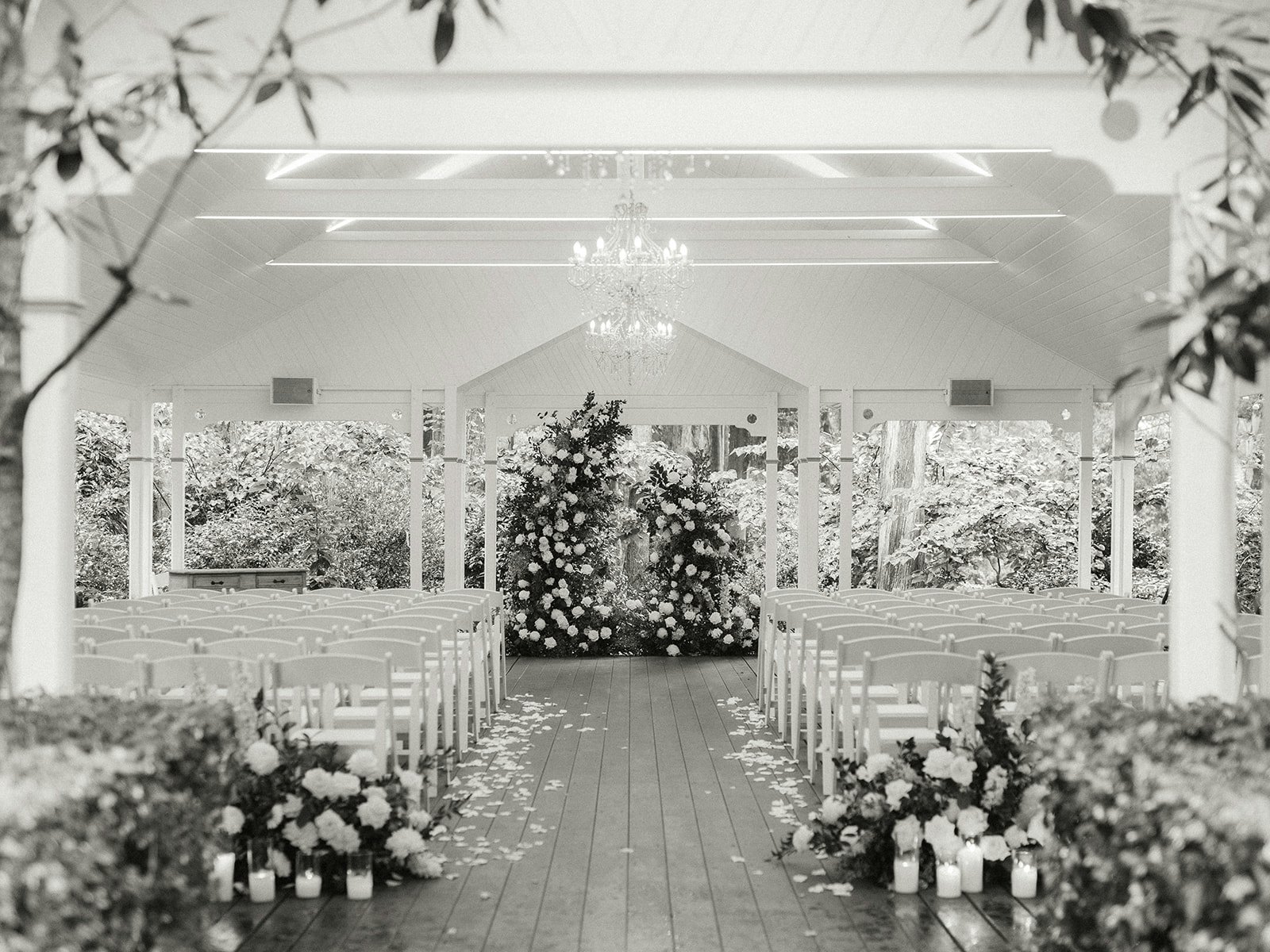 Wedding ceremony location with floral arbour and candles