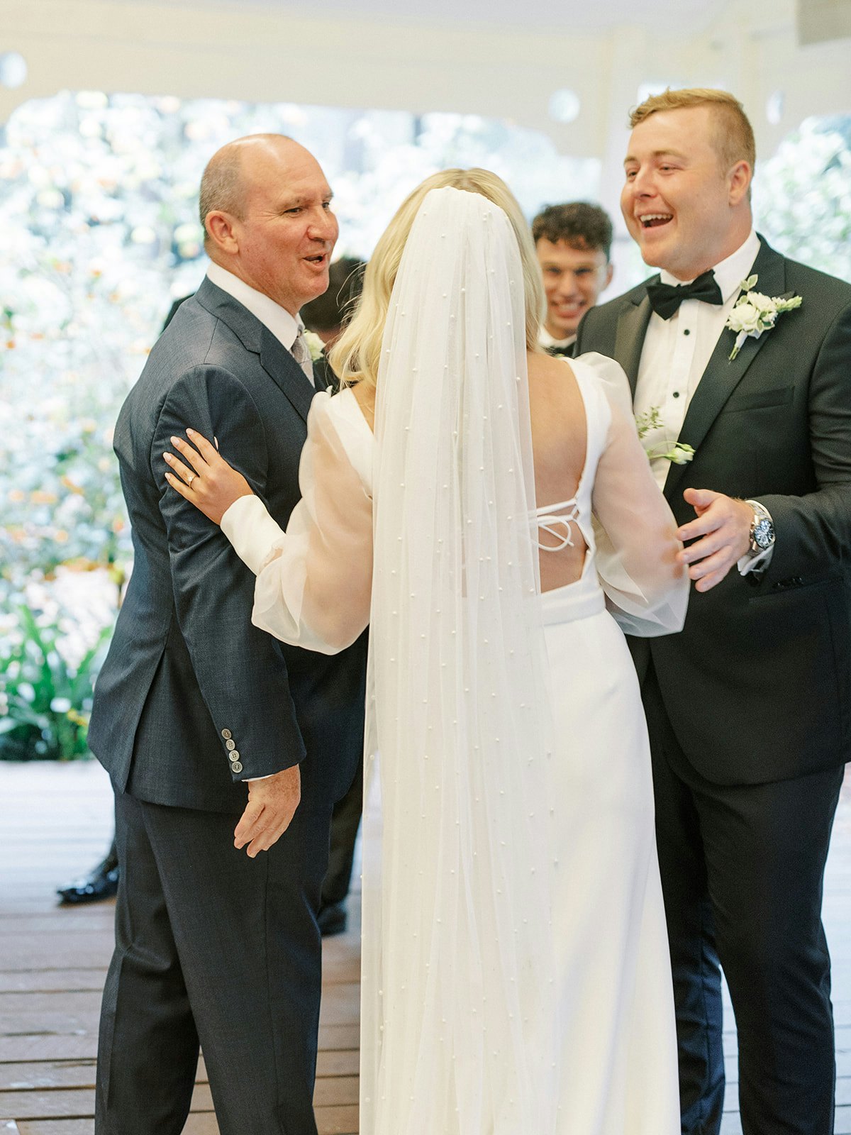 Bride and father and groom laughing