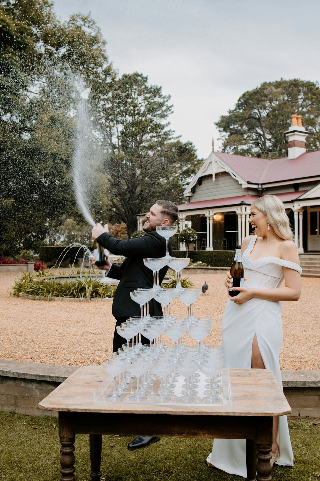Bride and groom spraying champagne