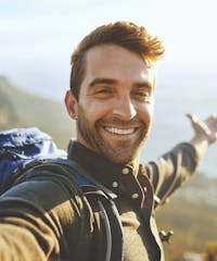 smiling man with backpack on his back