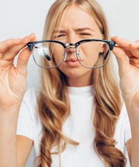 blond woman with glasses squinting at camera