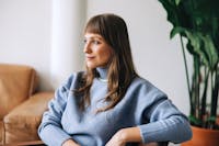Woman in a blue sweater sitting in a chair