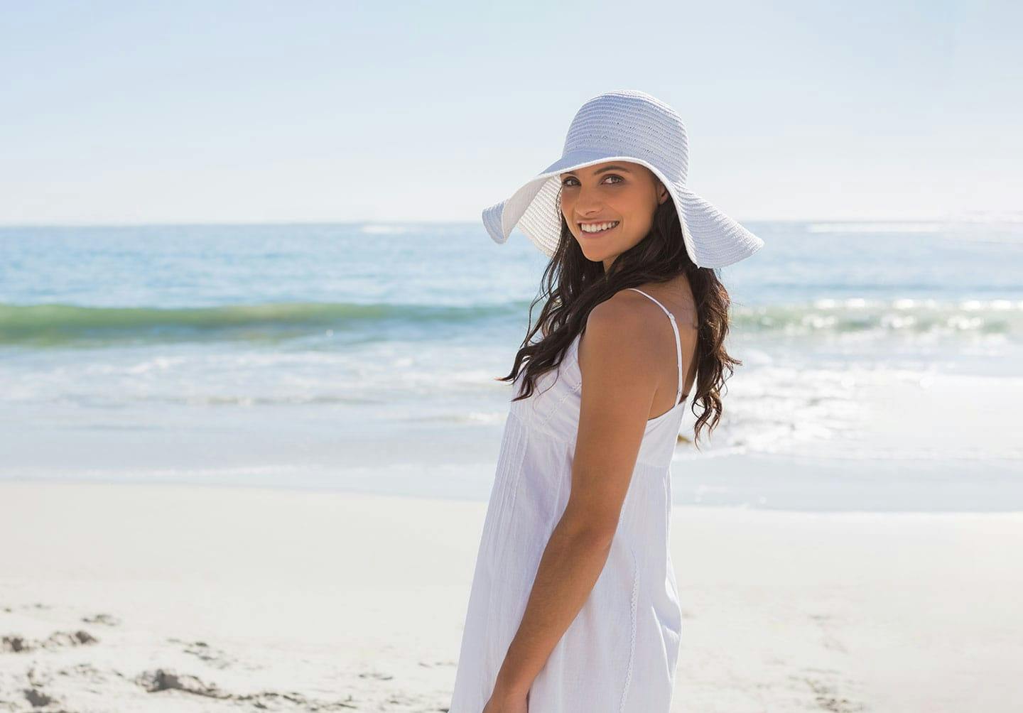woman at the beach after EMSELLA treatment in Denver