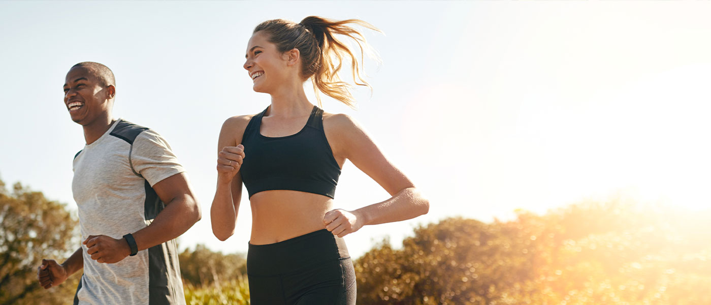 Happy couple jogging after medical weight loss program from Genesis Lifestyle Medicine.