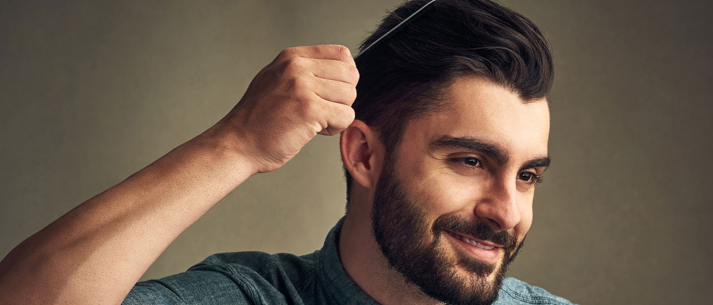 Man brushing his hair after hair restoration at Genesis Lifestyle Medicine.