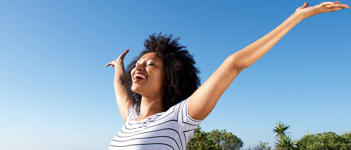 Happy woman outside after HRT from Genesis Lifestyle Medicine.