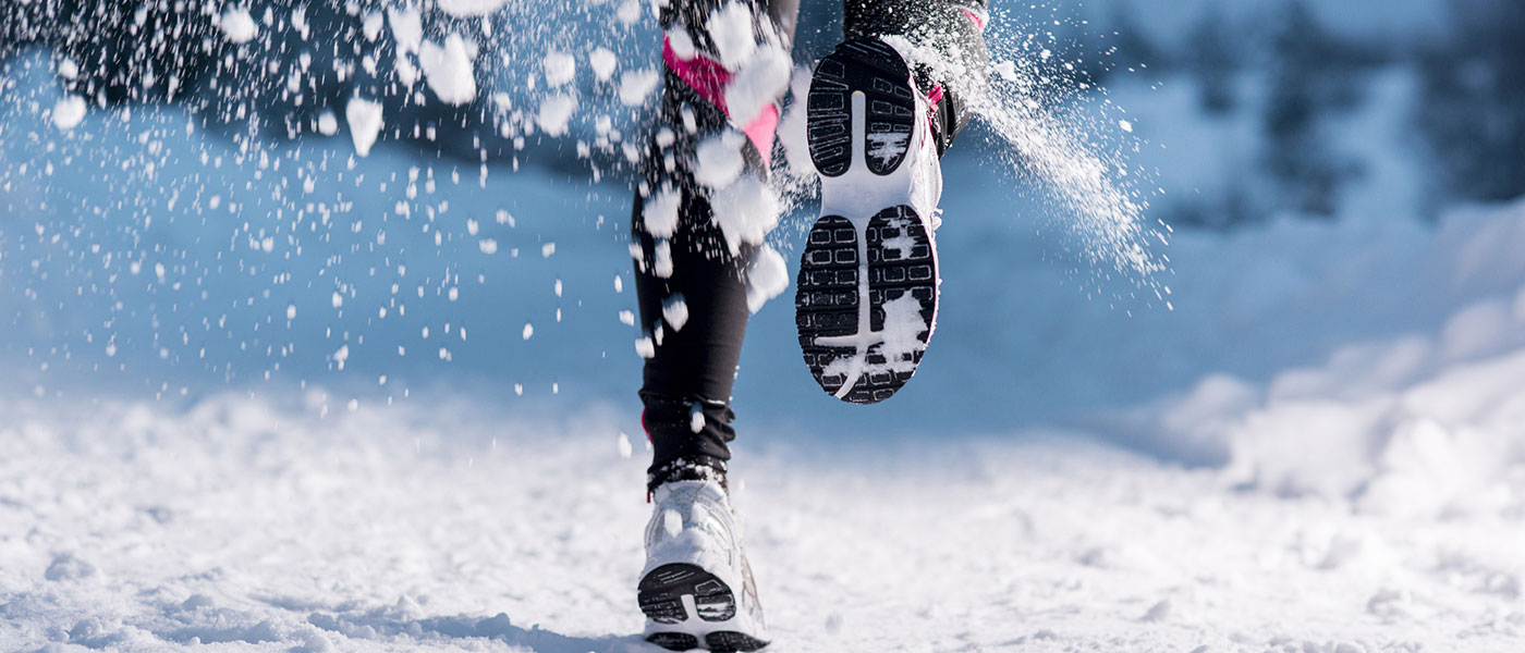 Woman running in the snow after weight loss treatment from Genesis Lifestyle Medicine.