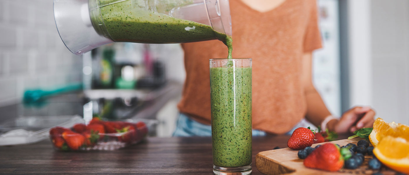 Woman making a healthy smoothie after treatment at Genesis Lifestyle Medicine. 