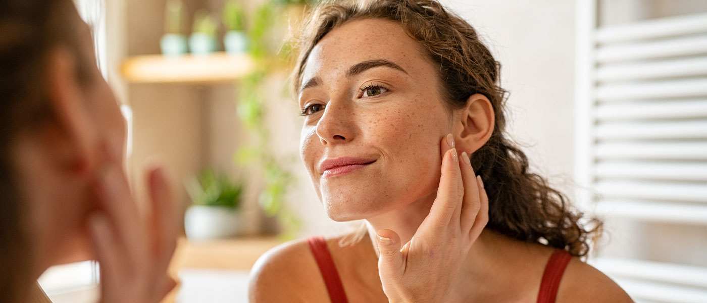 Woman looking at her clear skin after Botox from Genesis Lifestyle Medicine.