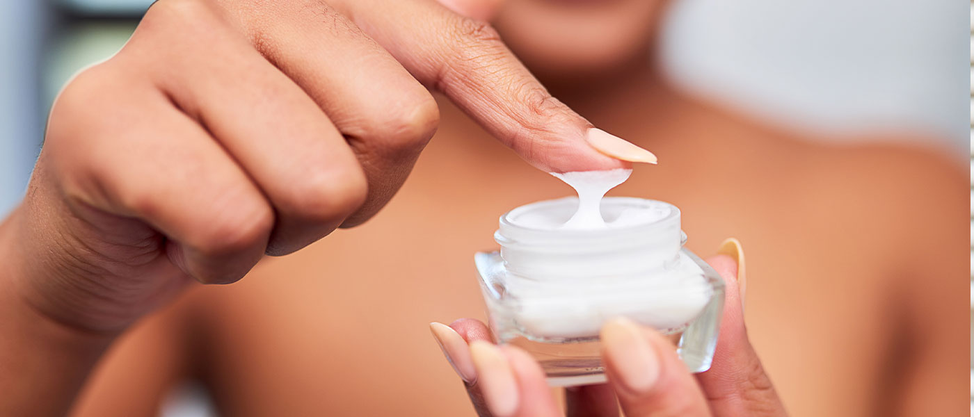 Woman holding skin care cream after Vampire Facial from Genesis Lifestyle Medicine.