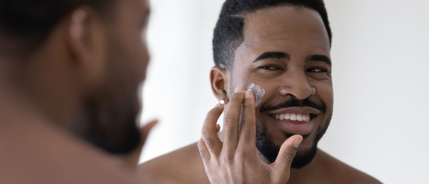 Man applying cream on his face after microneedling from Genesis Lifestyle Medicine.