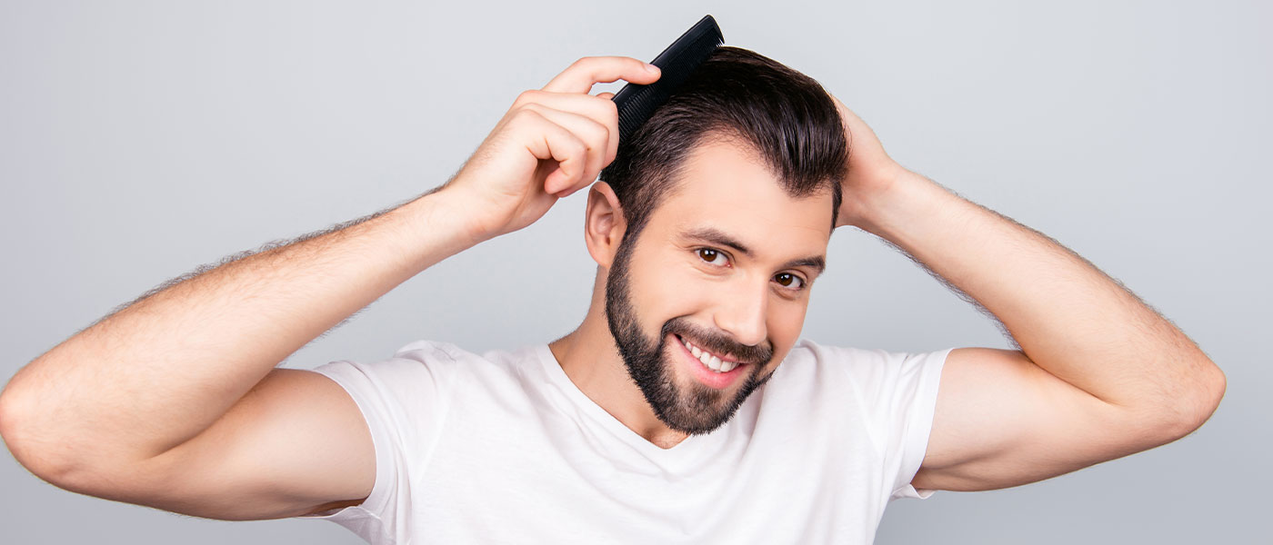Man brushing his hair after hair restoration from Genesis Lifestyle Medicine.