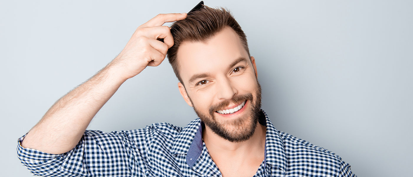 Man combing his hair after a hair transplant from Genesis Lifestyle Medicine.