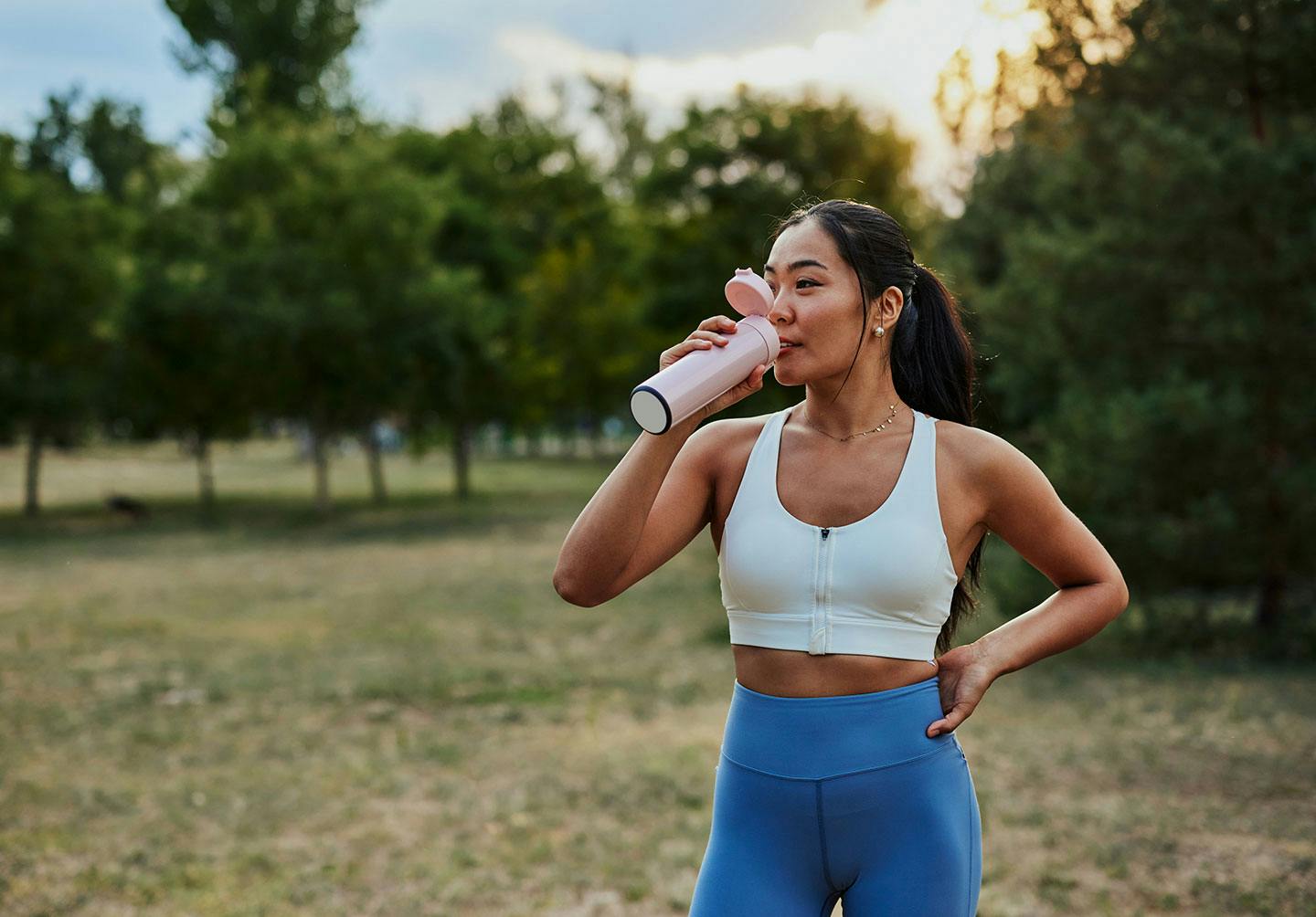 Woman in athletic wear drinking water after completing a medical weight loss program at Genesis Lifestyle Medicine.