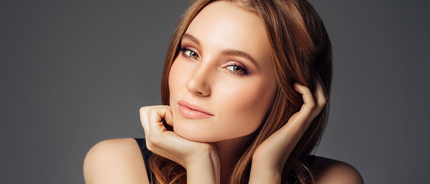 Smiling woman after receiving dermal fillers from Genesis Lifestyle Medicine.