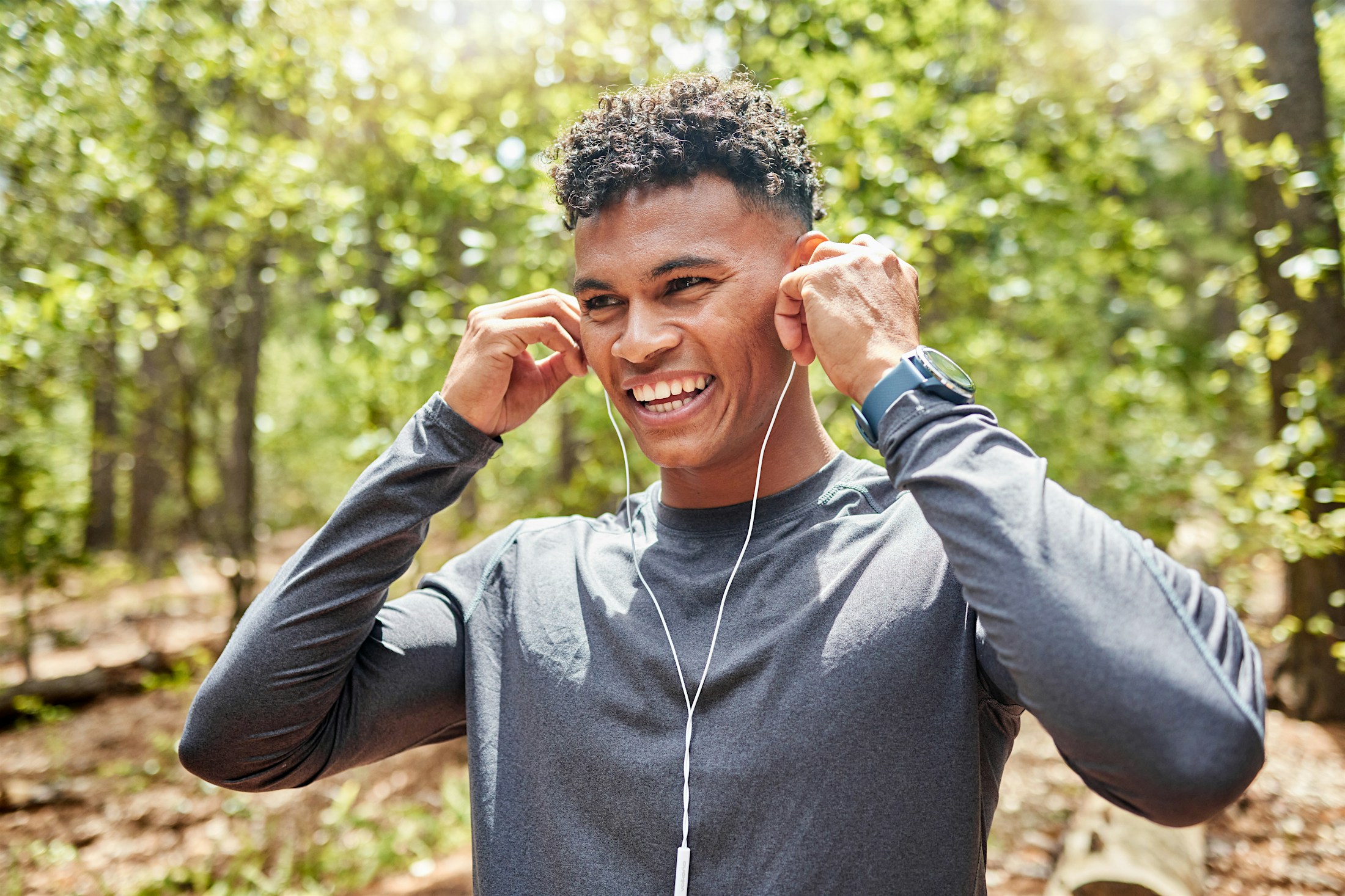 a man putting in his earbuds while on a run outside after getting GLP-1 in Sacramento.