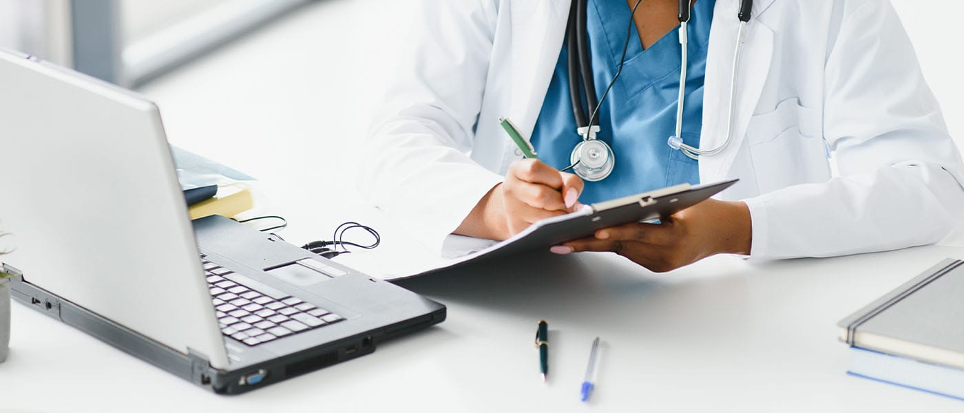 Genesis Lifestyle Medicine doctor taking notes on telehealth call.