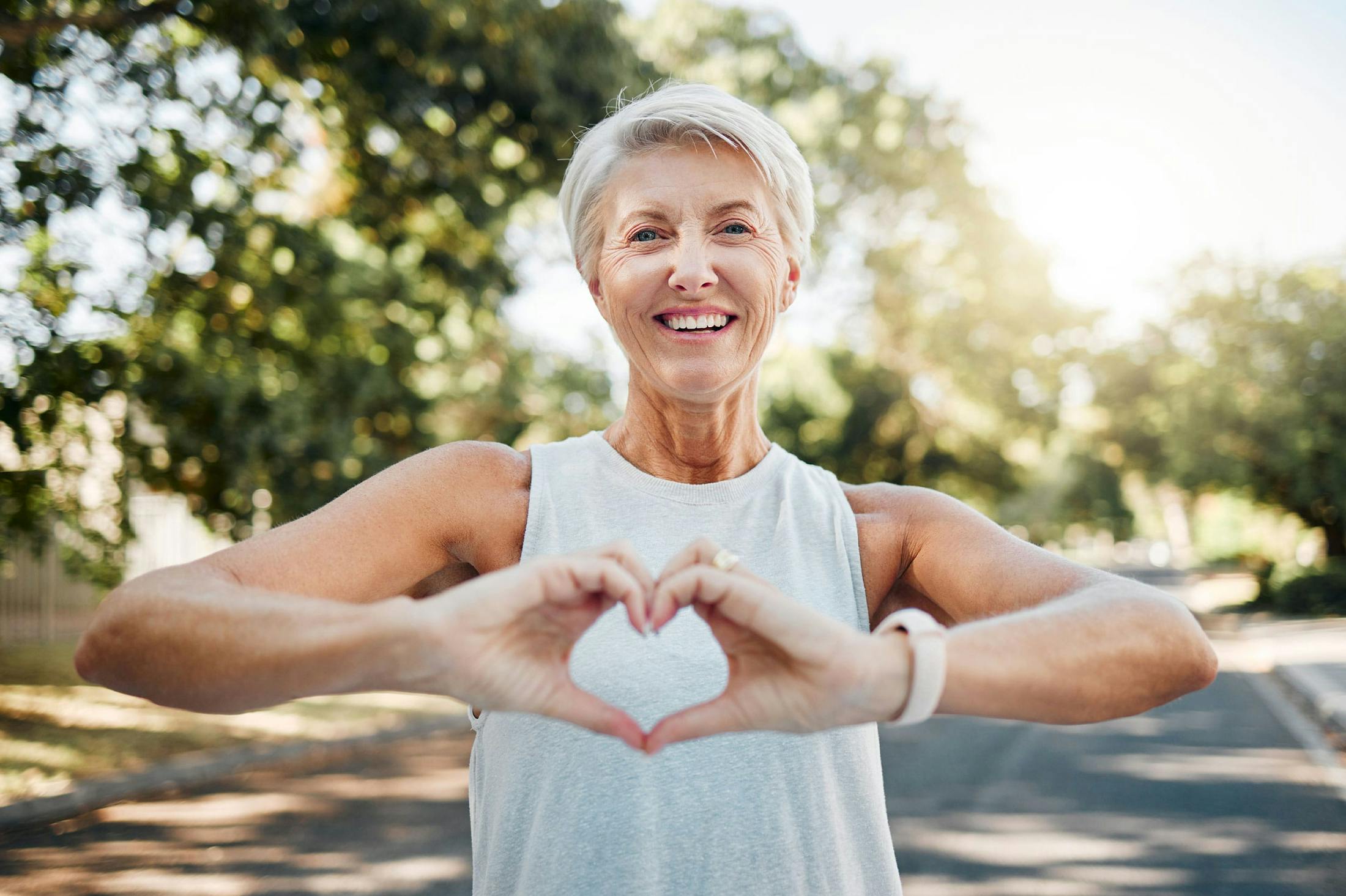 Woman making a heart shape with her hands after completing medical weight loss program at Genesis Lifestyle Medicine.