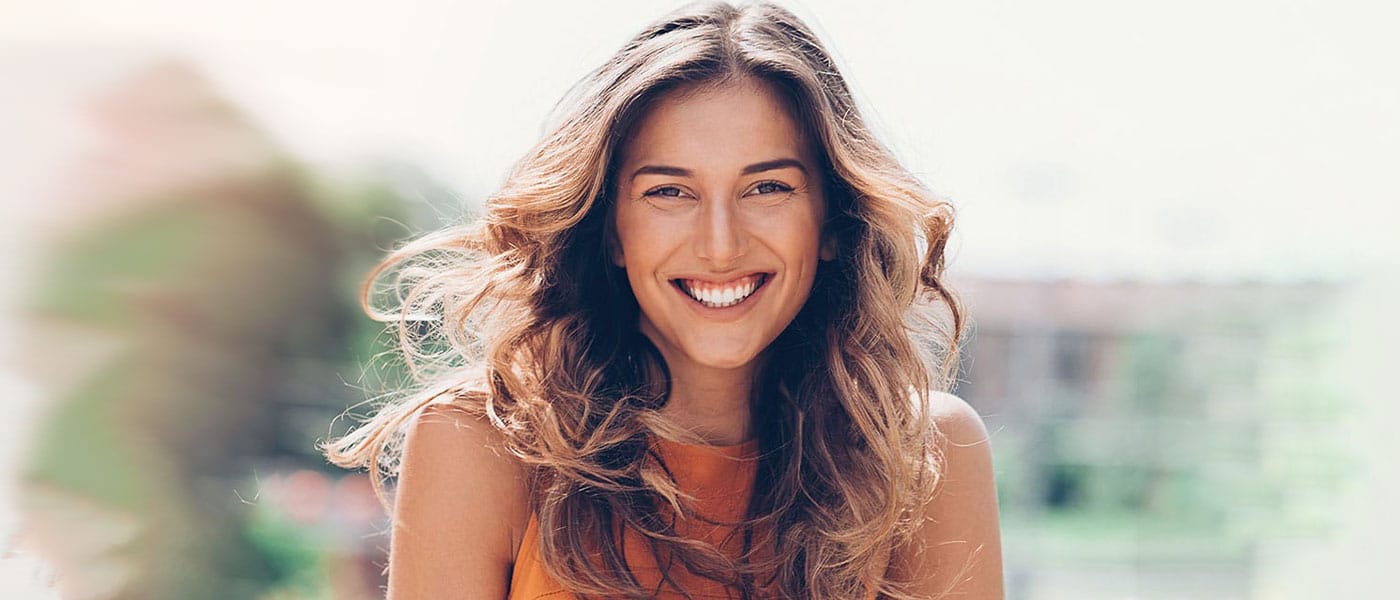 Woman happy with her hair restoration results from Genesis Lifestyle Medicine.