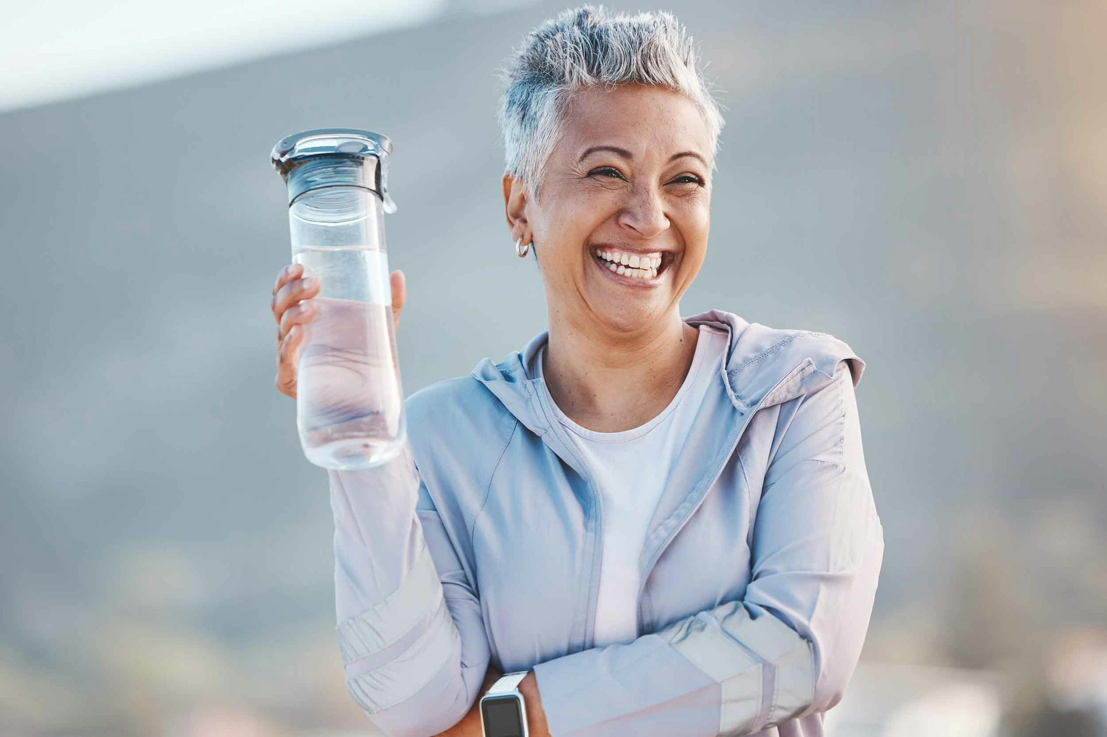 Smiling woman holding thermos after THERMIva vaginal rejuvenation treatment in Portland, TX