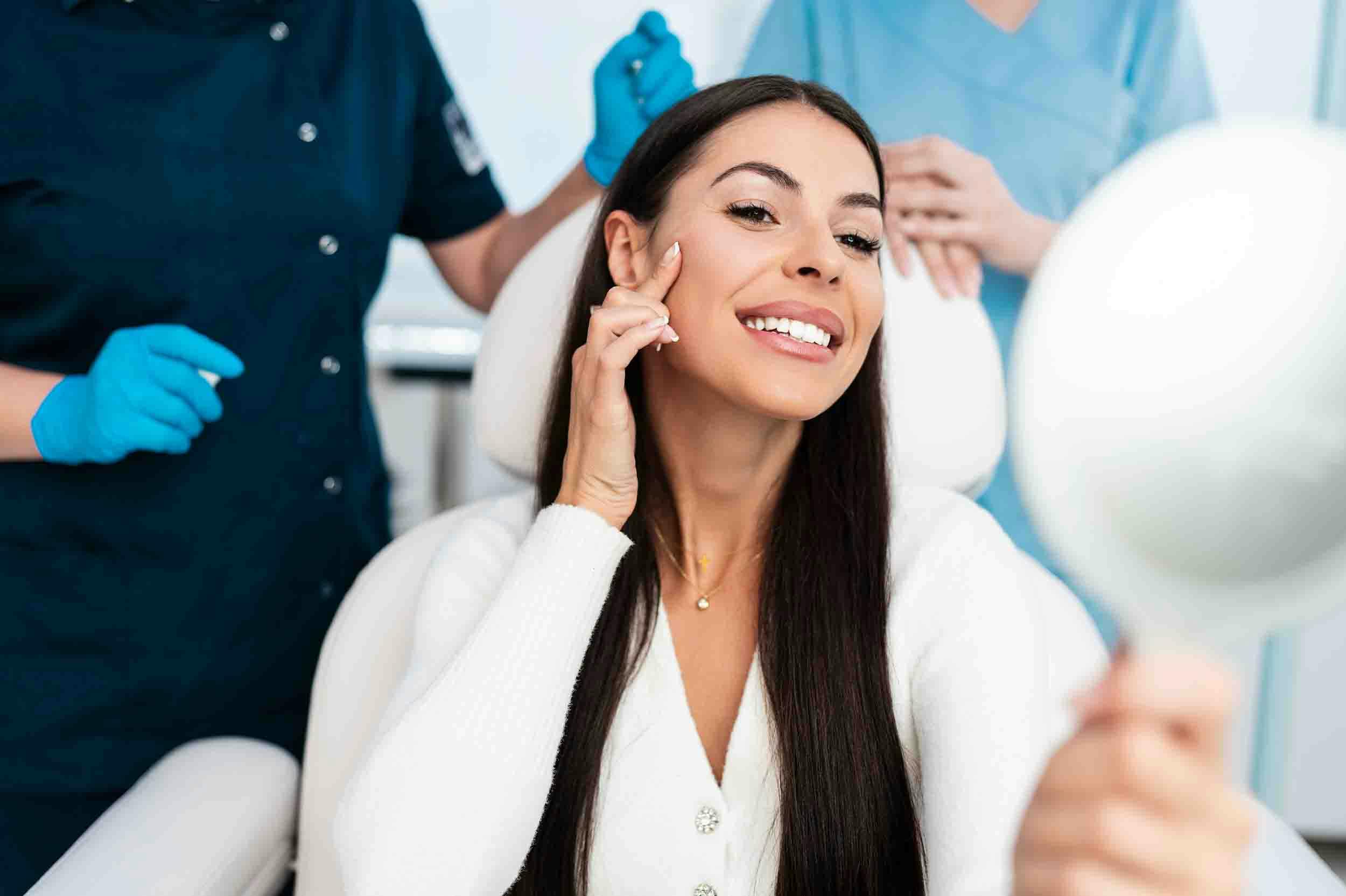 woman looking in mirror after receiving dermal fillers in Denver