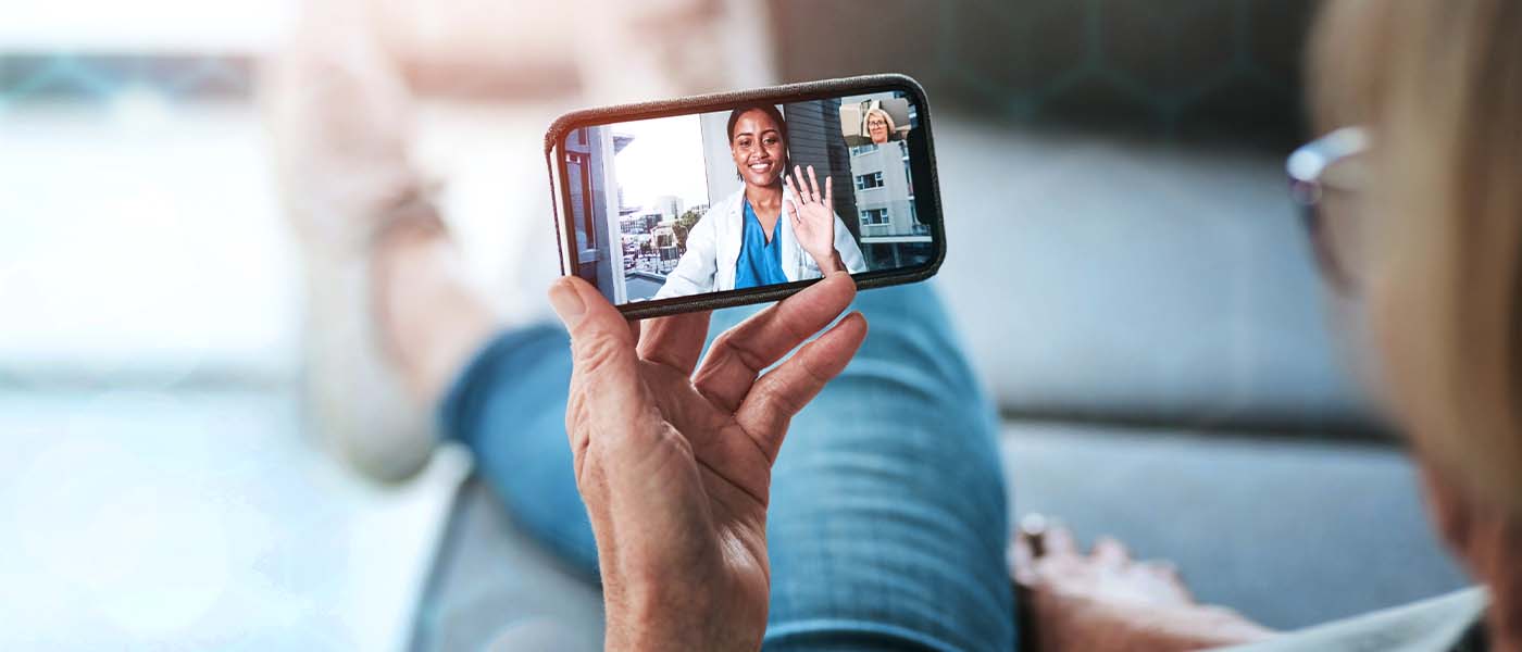 Woman smiling during a virtual telehealth appointment with Genesis Lifestyle Medicine.