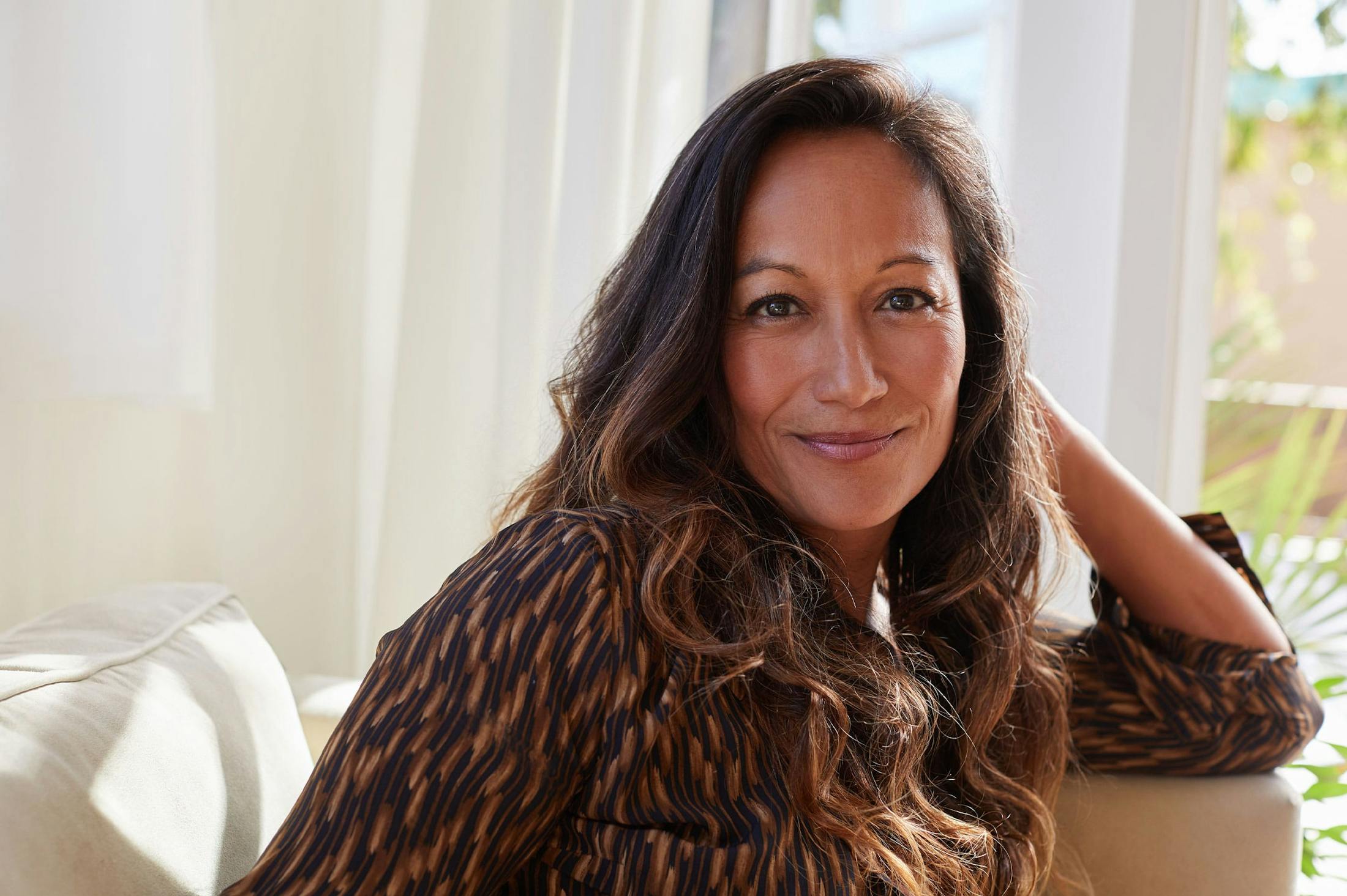 Happy woman at home after receiving hormone therapy from Genesis Lifestyle Medicine.