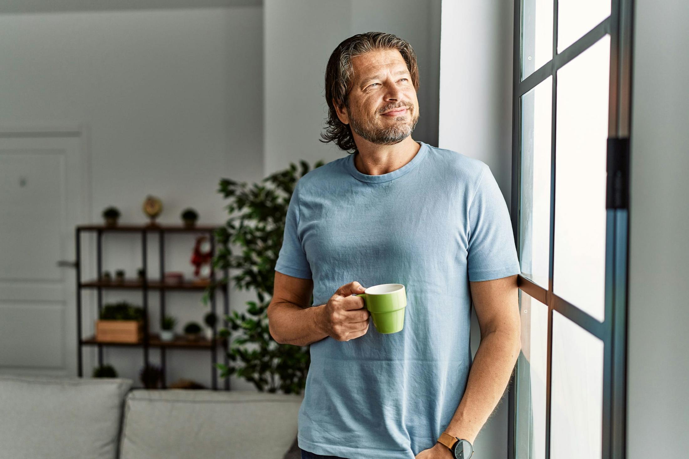 Happy man drinking coffee after HGH from Genesis Lifestyle Medicine.