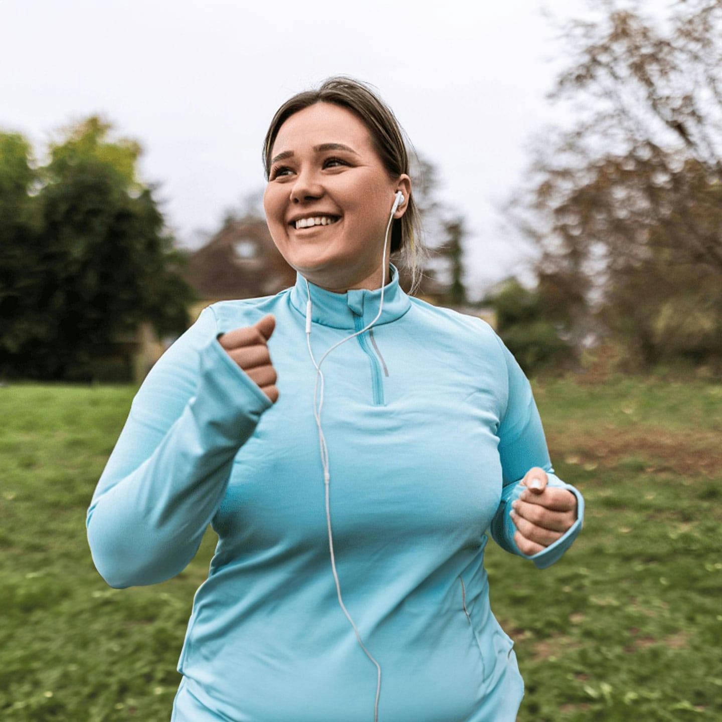a woman running in a field while listening to something on headphones after getting GLP-1 weight loss medication in Bakersfield.
