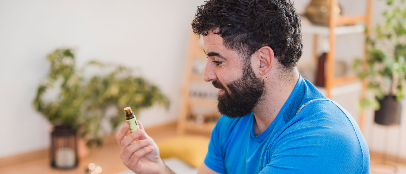 Man holding essential oil and considering weight loss treatment from Genesis Lifestyle Medicine.