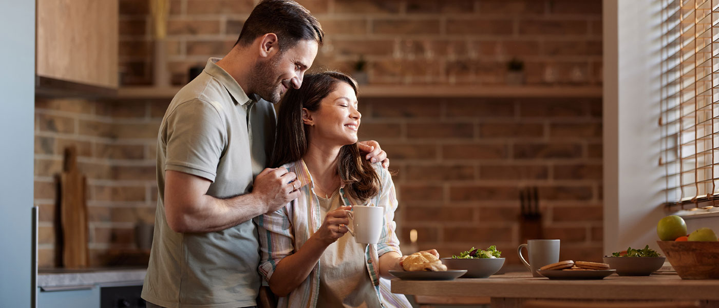 Happy couple in the kitchen after GAINSWave therapy from Genesis Lifestyle Medicine.