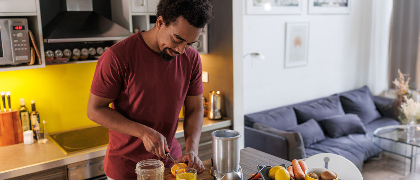 Man cutting fruit after receiving TRT from Genesis Lifestyle Medicine.
