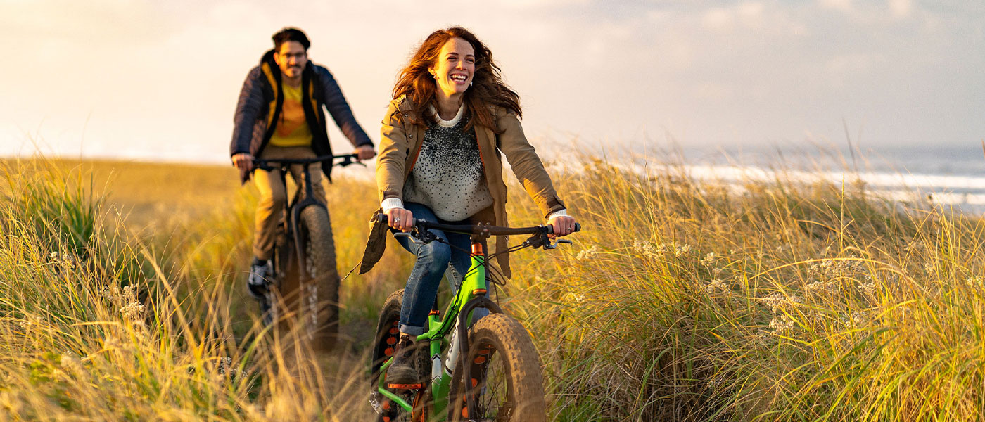 Happy couple riding bikes after medical weight loss program from Genesis Lifestyle Medicine.