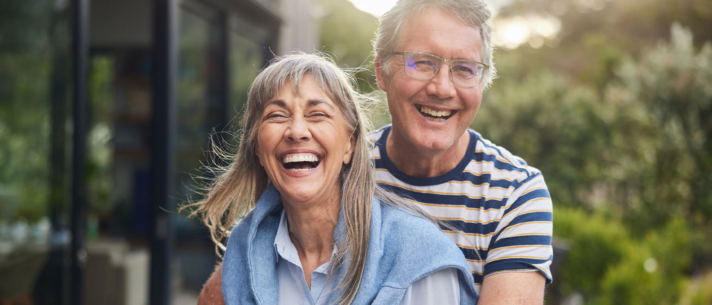 Smiling couple outdoors feeling revitalized and energetic thanks to Sermorelin treatment at Genesis Lifestyle Medicine.