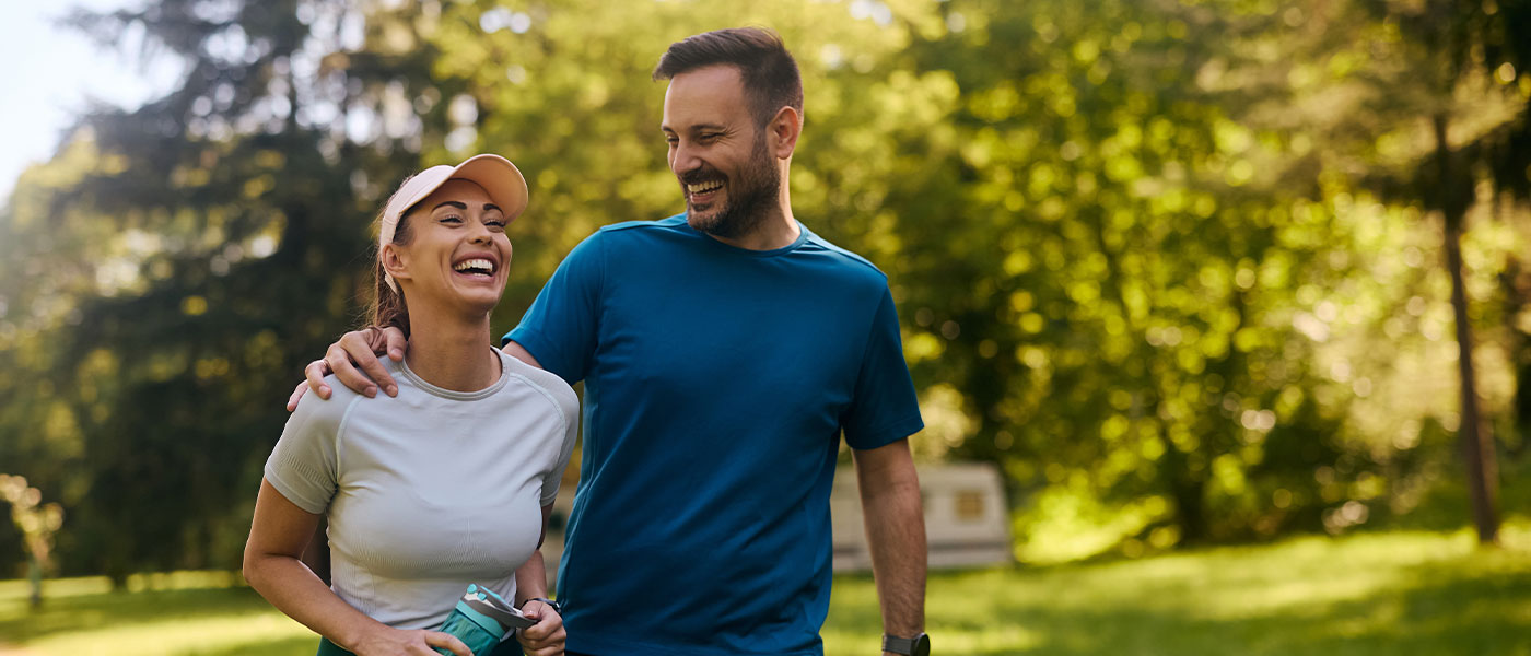 oyful couple walking hand in hand, embracing a healthy lifestyle supported by Sermorelin from Genesis Lifestyle Medicine.