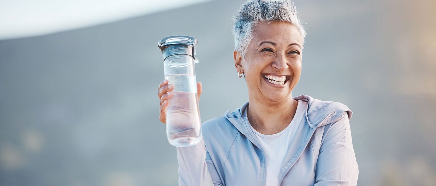 older woman drinking water after taking NAD+