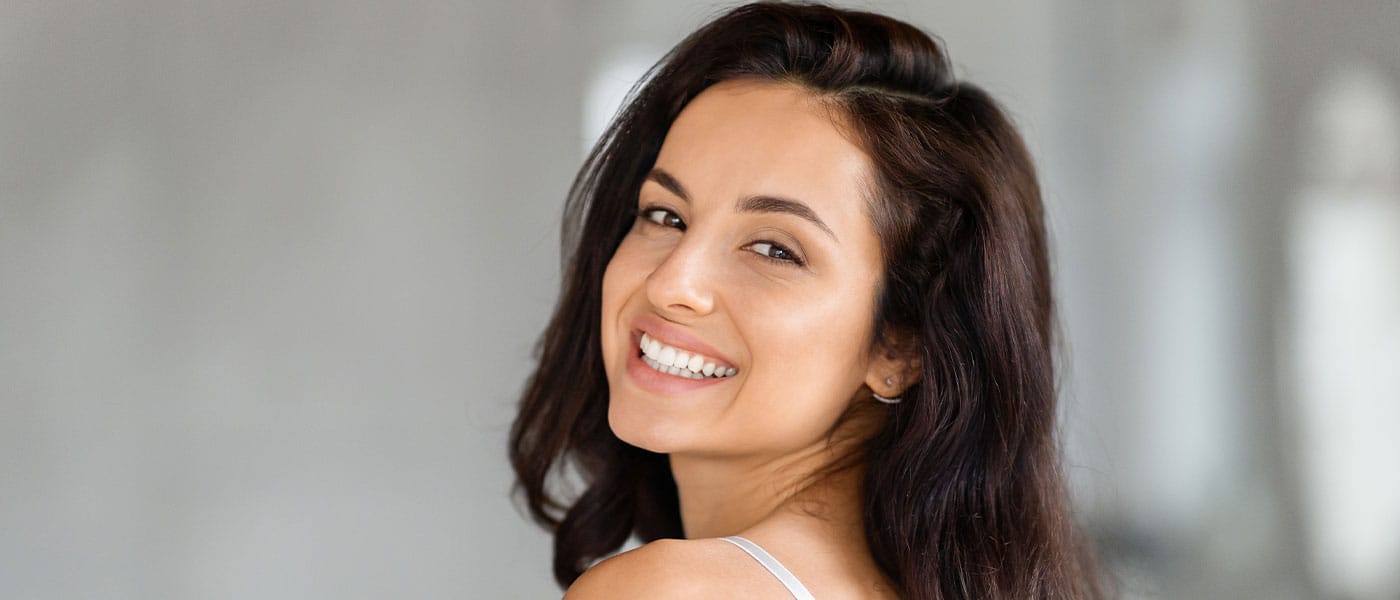 happy woman smiling with healthy hair and skin after taking NAD+
