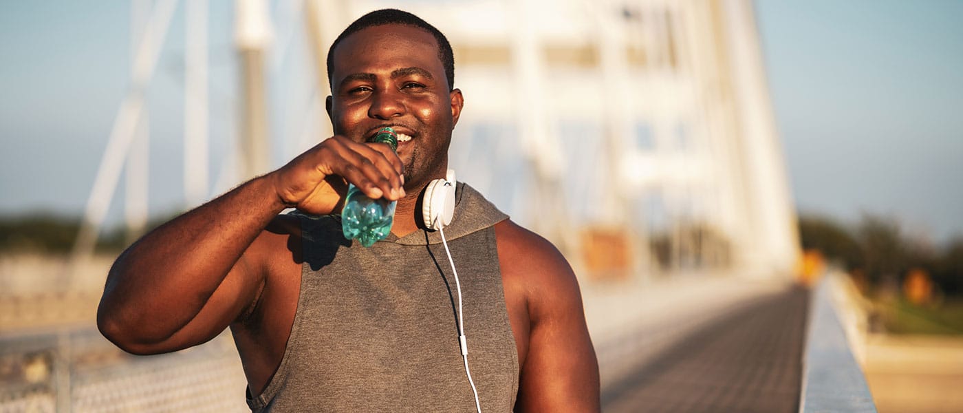 man drinking water outside after starting sermorelin therapy