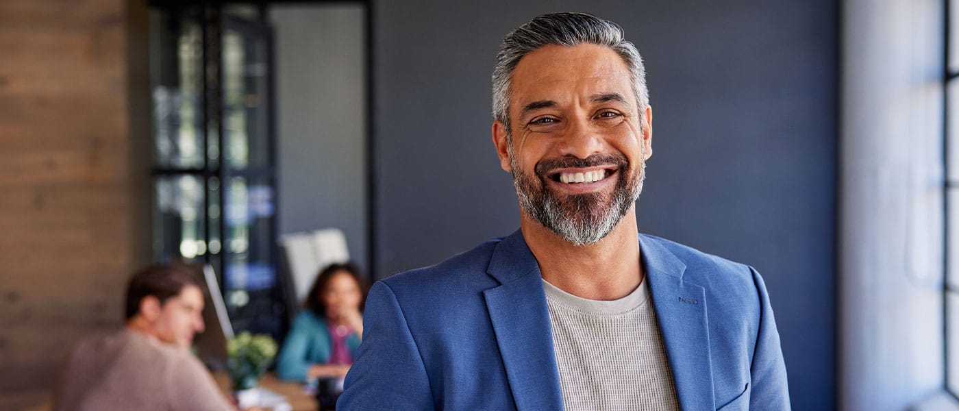 older man at work smiling after starting P-Long treatment