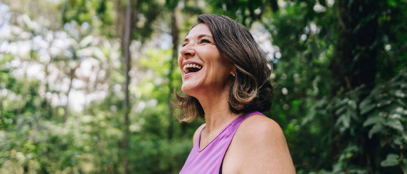 older woman smiling outside after starting hormone therapy