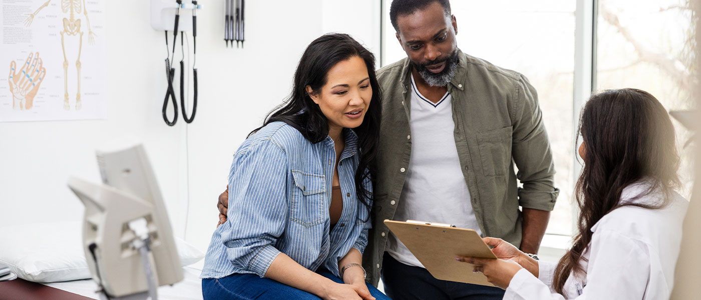 couple discussing hormone replacement therapy with a doctor