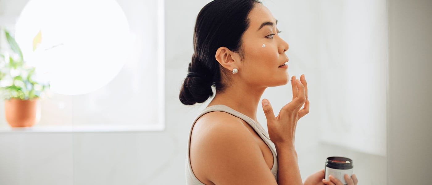 woman doing skincare after starting hormone therapy