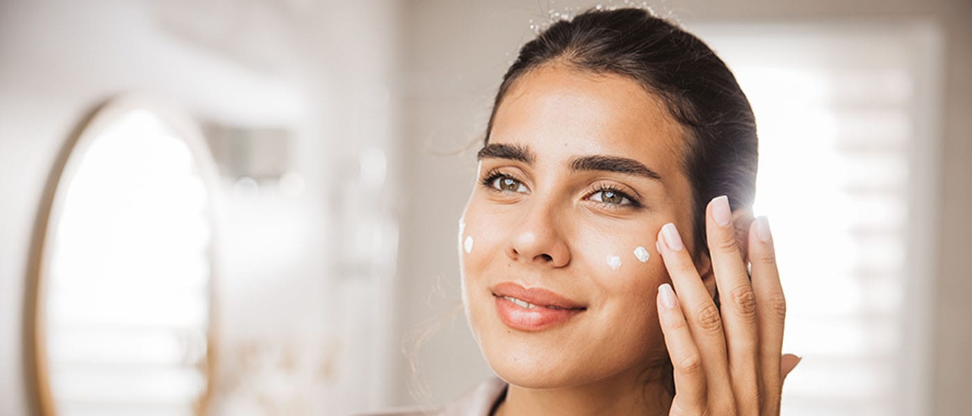 woman putting on skincare after getting aesthetic skin treatment