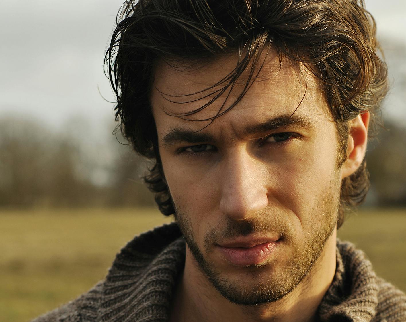 Man with lots of hair standing out in field