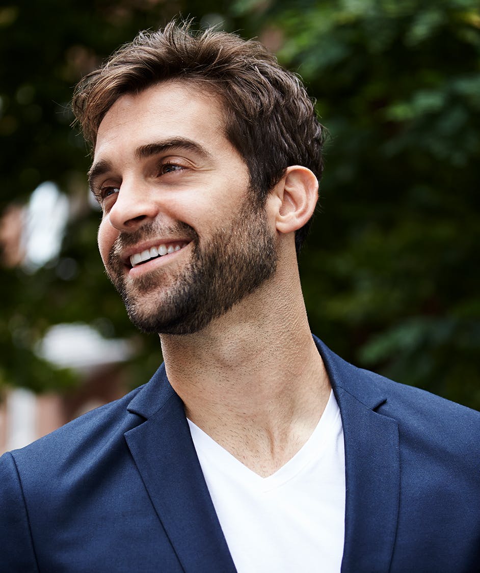 Young man with brown hair in a blue suit jacket.