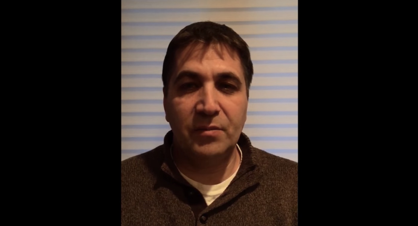 Man Standing in Front of Blinds