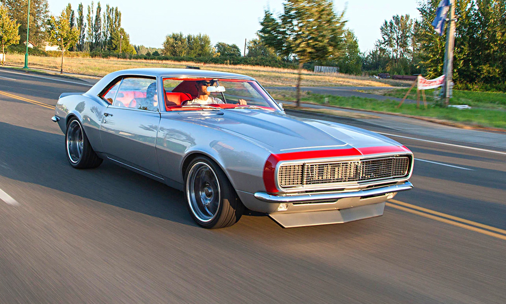 1968 Camaro featuring Universal Pro Series Low Back seats with SPORT-XR design including red vinyl, red suede, and red contrast stitching. Paired with matching rear seat and waterfall console, door panels, center console, dash pad, headliner, and carpet kit.