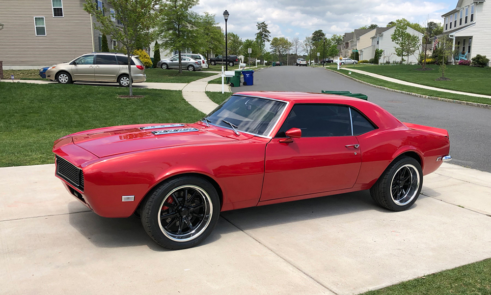 1968 Camaro Sport featuring Universal Pro Series Low Back seats with SPORT design including black vinyl and red contrast stitching. Paired with matching rear seat, door panels, and center console.